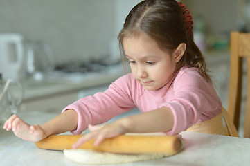 Image showing Little girl kneading dough