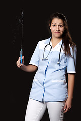 Image showing Young female doctor with stethoscope and syringe