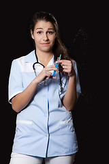 Image showing Young female doctor with stethoscope and syringe