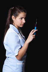 Image showing Young female doctor with stethoscope and syringe