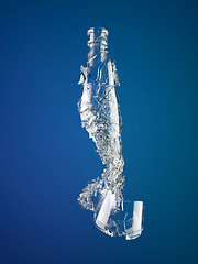 Image showing Pieces of shattered empty bottle on blue