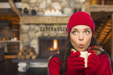 Image showing Mixed Race Girl Enjoying Warm Fireplace and Holding Mug