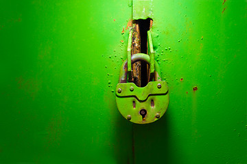 Image showing old padlock on the iron green texture