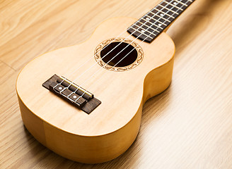 Image showing Ukulele over the wooden background