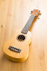 Image showing ukulele on wood background