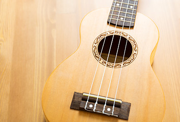 Image showing ukulele on wood background