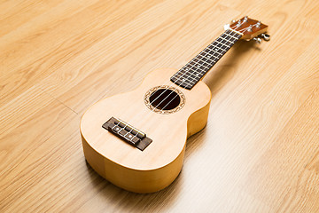 Image showing Ukulele over the wooden background