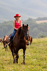 Image showing Woman in red hat riding