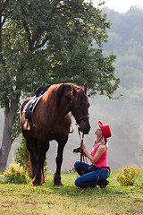 Image showing Woman in red hat riding