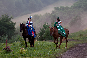 Image showing Two women in the royal baroque dress riding