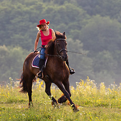 Image showing Woman in red hat riding