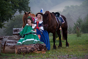 Image showing Two women in the royal baroque dress riding