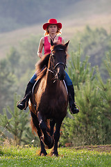 Image showing Woman in red hat riding