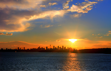 Image showing Sun setting over Sydney Harbour with City silhouette