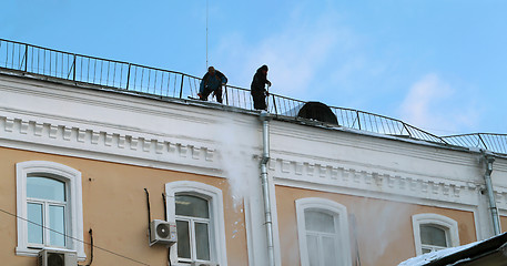 Image showing Workers clean snow from the roof