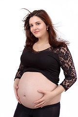 Image showing beautiful pregnant woman tenderly holding her tummy isolated on white background