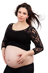 Image showing beautiful pregnant woman tenderly holding her tummy isolated on white background