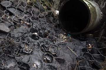 Image showing environmental pollution. engine oil from a pipe