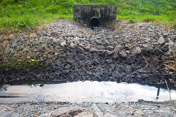 Image showing environmental pollution. engine oil from a pipe