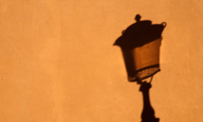 Image showing shadow of street lamp on yellow wall