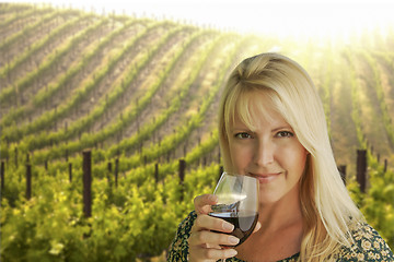 Image showing Attractive Woman Enjoying a Glass of Wine at the Vineyard