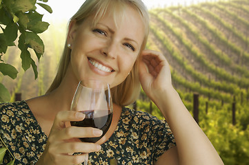 Image showing Attractive Woman Enjoying a Glass of Wine at the Vineyard