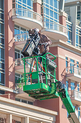 Image showing tv camera man recording event in a city on a lift