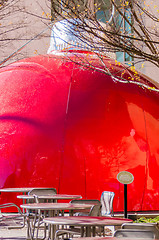 Image showing giant red bauble on city plaza behind eating table area