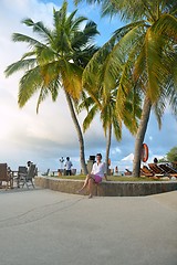 Image showing Beautiful young woman with a drink by the sea