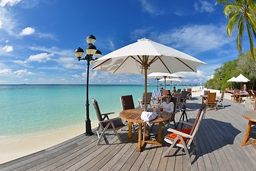 Image showing Beautiful young woman with a drink by the sea