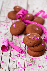 Image showing fresh chocolate cookies, coffee beans, pink ribbons and confetti