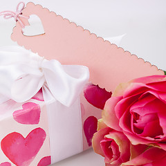 Image showing Gift box with an empty tag, next to three roses