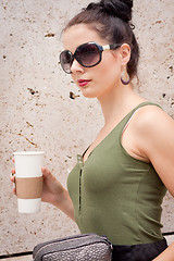 Image showing attractive young woman with smartphone and sunglasses outdoor