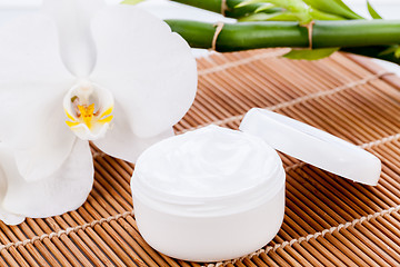 Image showing cosmetic face cream on wooden background 