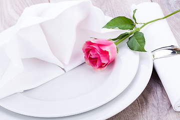 Image showing Table setting with a single pink rose