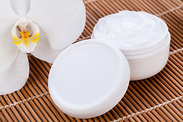 Image showing cosmetic face cream on wooden background 