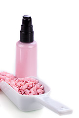Image showing pink body lotion in dispenser and aroma salt isolated