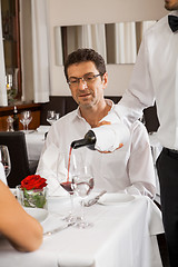 Image showing Waiter serving a couple in a restaurant