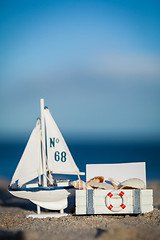 Image showing sailing boat and seashell in sand decoration closeup