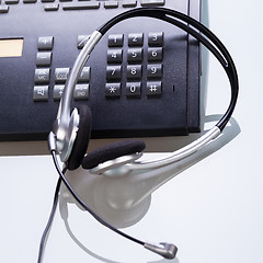 Image showing office desk with telephone and headset objects 