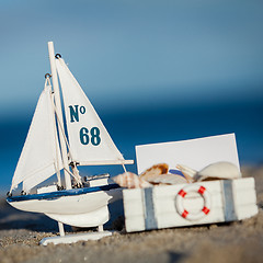 Image showing sailing boat and seashell in sand decoration closeup