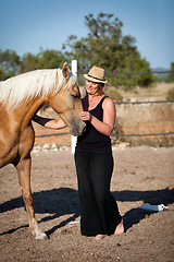 Image showing young woman training horse outside in summer