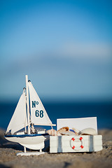 Image showing sailing boat and seashell in sand decoration closeup