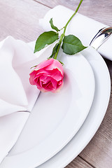 Image showing Table setting with a single pink rose