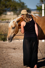 Image showing young woman training horse outside in summer