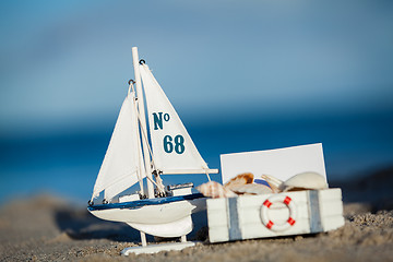 Image showing sailing boat and seashell in sand decoration closeup