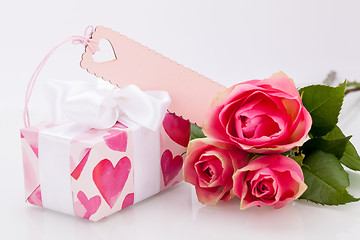 Image showing Gift box with an empty tag, next to three roses