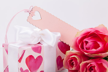 Image showing Gift box with an empty tag, next to three roses