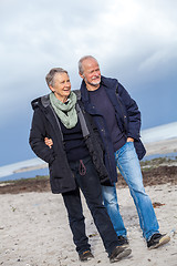 Image showing happy elderly senior couple walking on beach