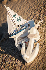 Image showing sailing boat and seashell in sand decoration closeup